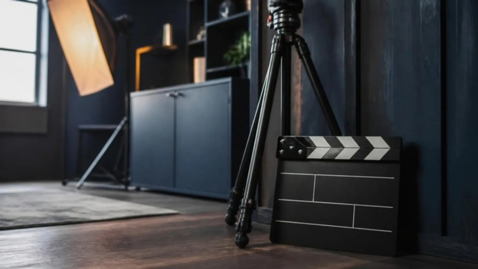 Filmklappe steht neben Stativ in einer warm beleuchteten Studioecke