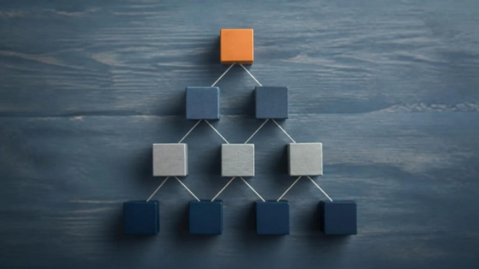 Holzblöcke bilden eine Pyramide, verbunden durch dünne Fäden von oben