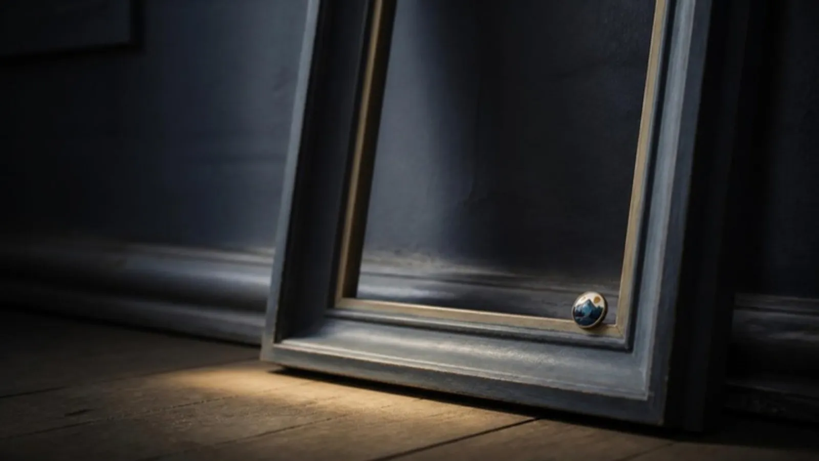 Kleiner runder Anstecker liegt in der Ecke eines leeren Bilderrahmens
